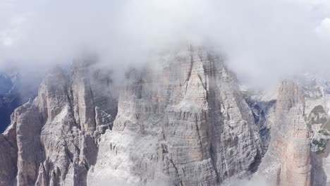 dense white clouds covering summit of tre cime di lavaredo in the dolomites, italy