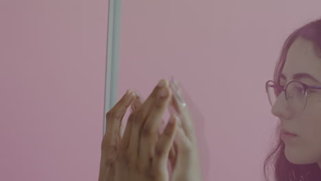 two people interacting in front of a pink wall