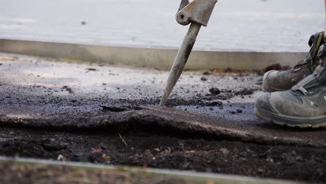 close up shot of a construction men breaking the tar with a drill machine