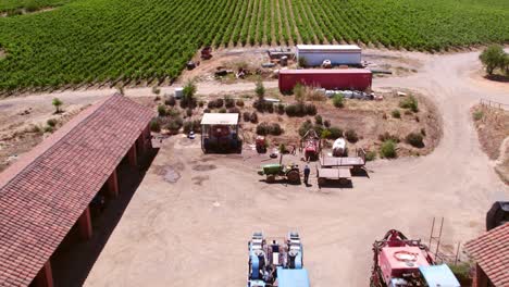 aerial shot of agriculture vehicles parked in cottage farm, cauquenes, maule valley, chile