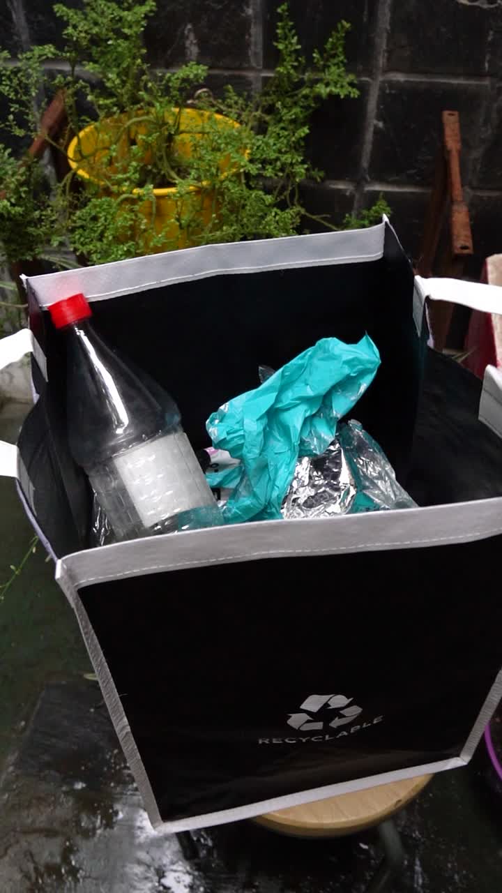 Home recycling detail showing a hand putting used plastic stuff, an essential step in preparing materials for sustainable reuse