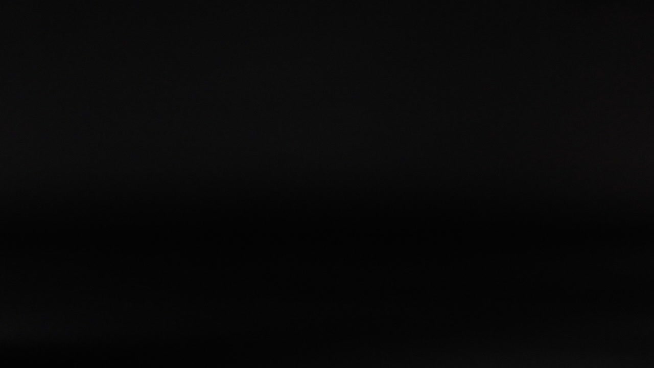 una pelota de golf se mueve a través de un fondo oscuro