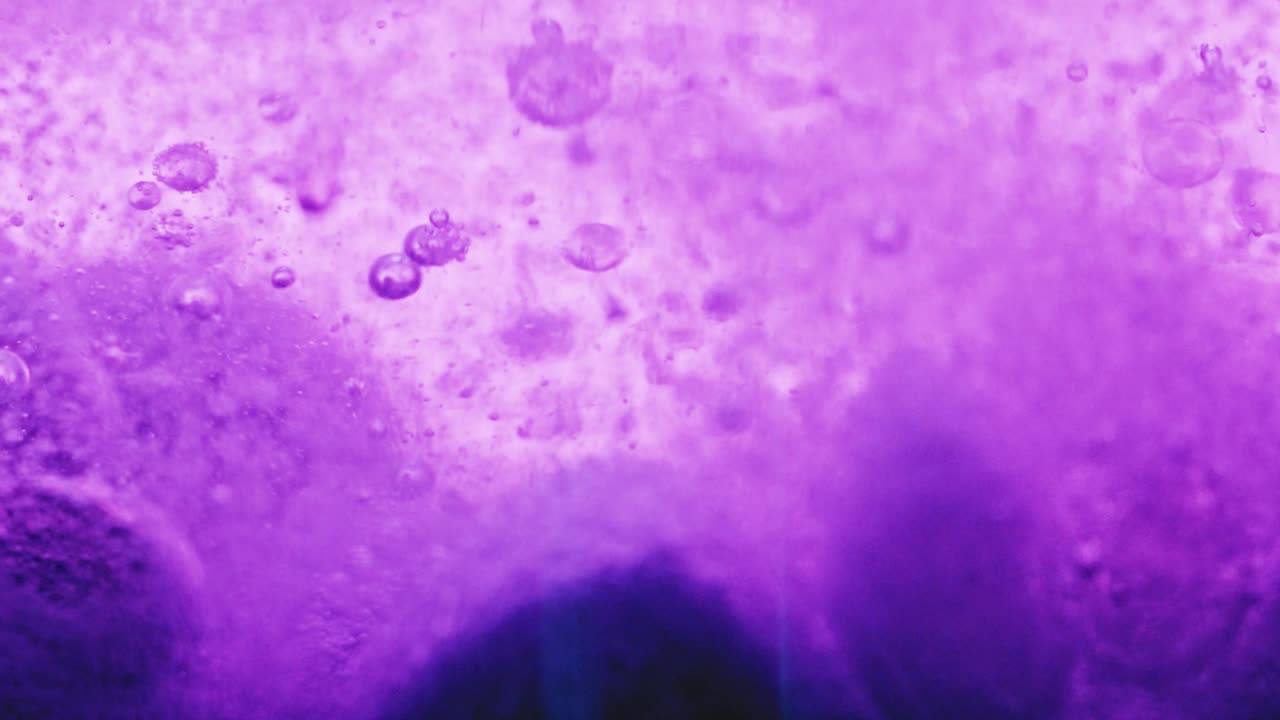 tiro macro de grandes burbujas violetas en el suelo con muchas pequeñas burbujas brillantes