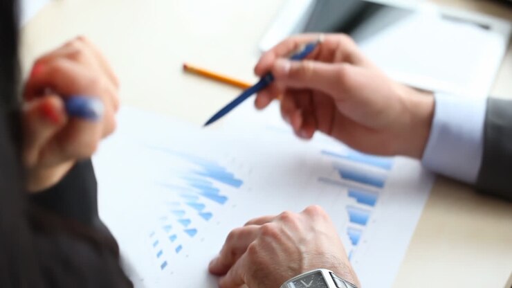Focused multicultural team collaborating, teamwork, productivity, and business innovation marketing analyzes data and discusses sales using charts papers