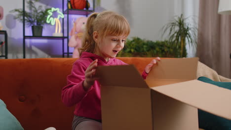 Niña-Feliz-Comprador-Desempacando-Caja-De-Cartón-Paquete-De-Entrega-Compras-En-Línea-Compra-En-Casa