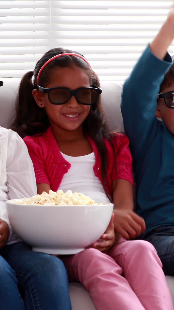 Cute children watching 3d movie on the sofa