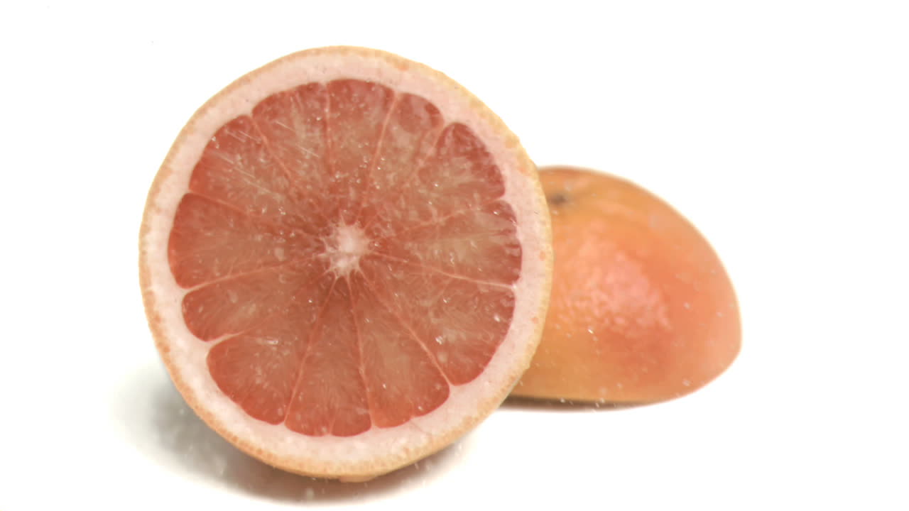 agua rociada sobre la toronja en cámara súper lenta