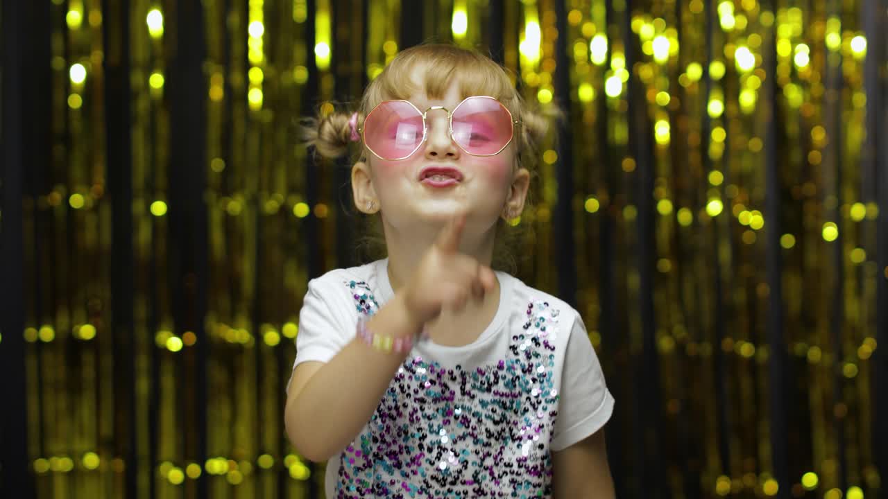 Child girl putting finger on lips making silence gesture, asking to keep secret. Shh. Be quite.