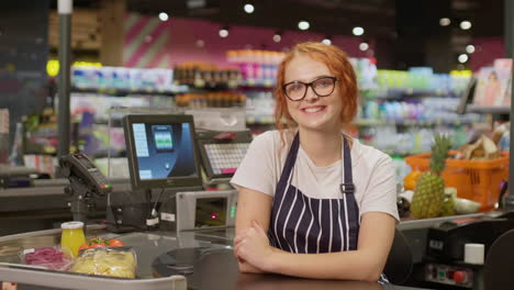 Joven-Vendedora-Sonriendo-Y-Mirando-A-La-Cámara-En-Un-Supermercado