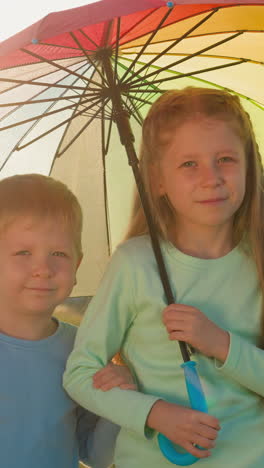 boy and girl find comfort under umbrella. children embrace rainy day with sun together forming memories under gentle pitter-patter of raindrops