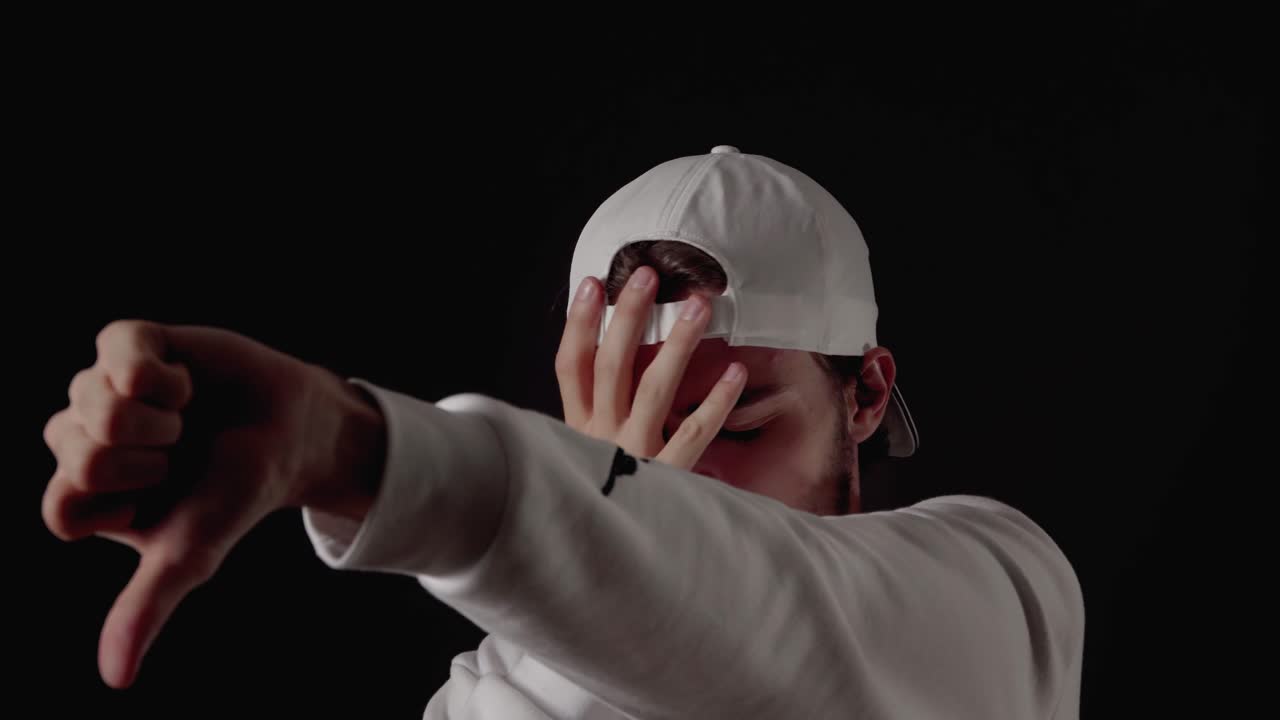 hombre de moda de los años 20 dando pulgares extremos hacia abajo, gesto de desaprobación, cierre, fondo negro