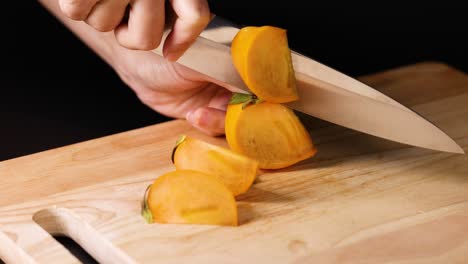 hands slicing persimmon with a sharp knife