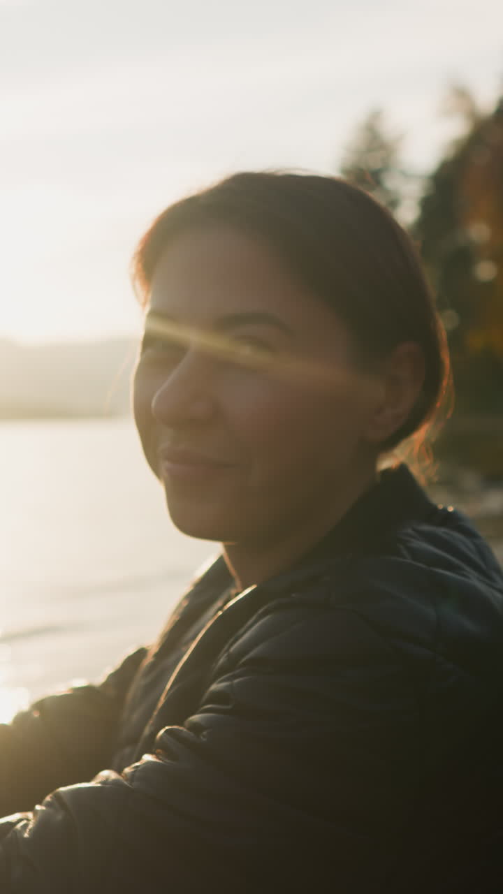 mujer comiendo croissant en la orilla del río al atardecer. hombre ofrece postre a su novia descansando en un picnic en la orillas del río juntos. noche romántica en la naturaleza