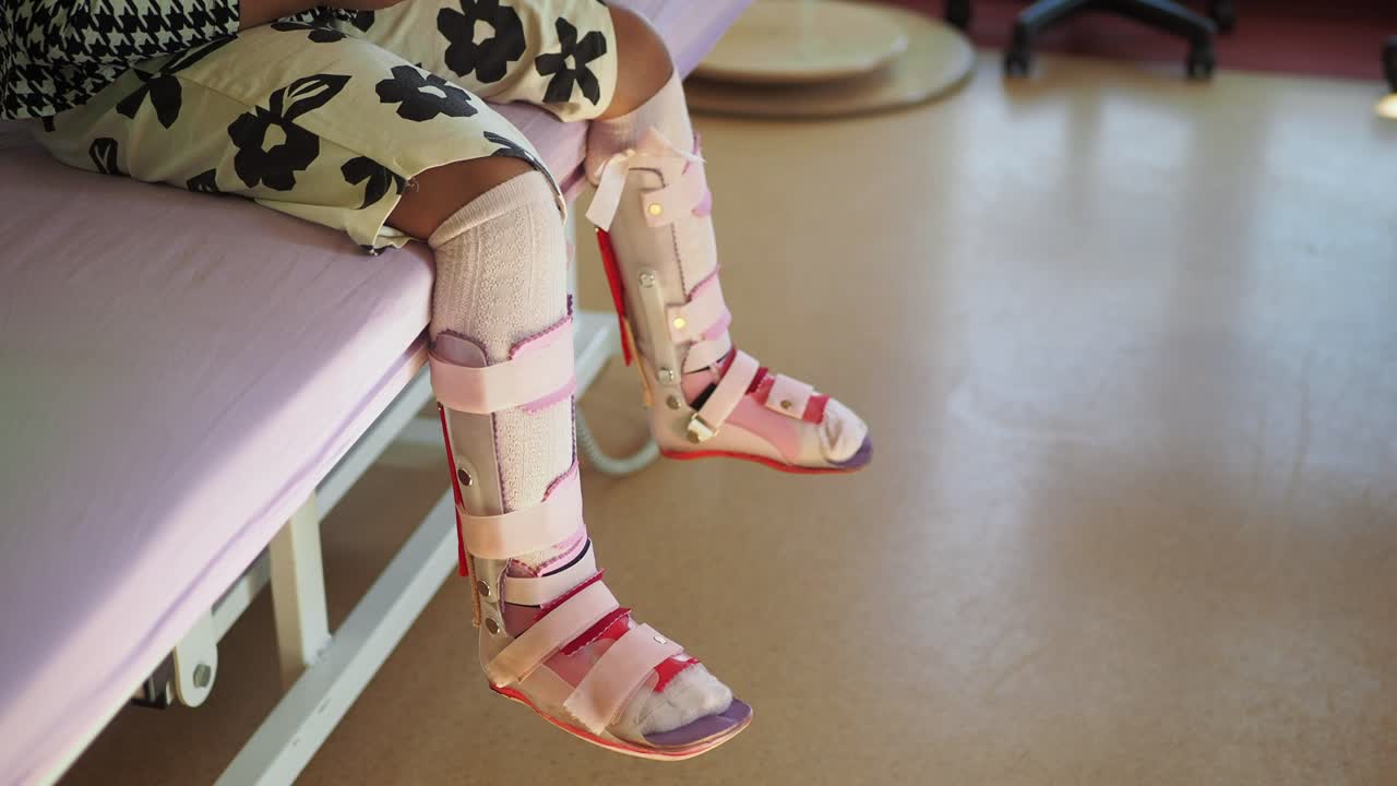 las piernas del niño en aparatos ortopédicos
