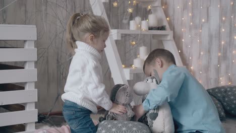 boy in light blue shirt plays toys with younger blond sister