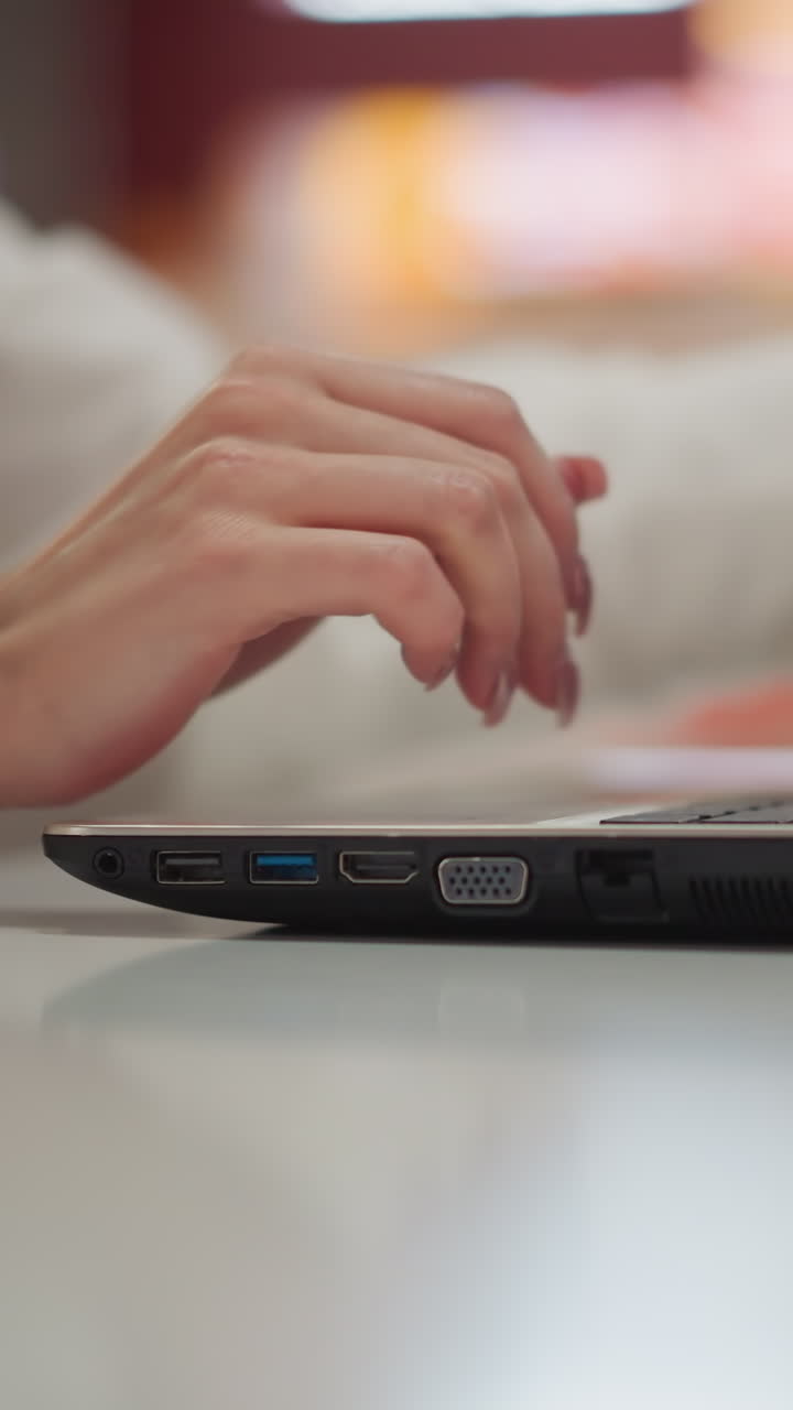 primer plano de una computadora portátil cerrada por una persona en un entorno de centro comercial moderno, con luces de fondo borrosas vibrantes y atmósfera urbana