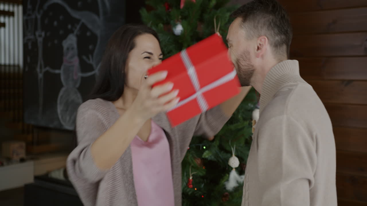una pareja intercambiando regalos de navidad.