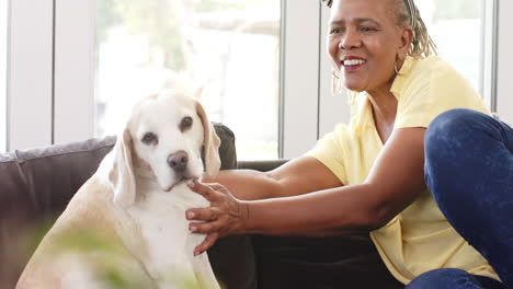 a senior african american woman sitting with her dog, both looking relaxed