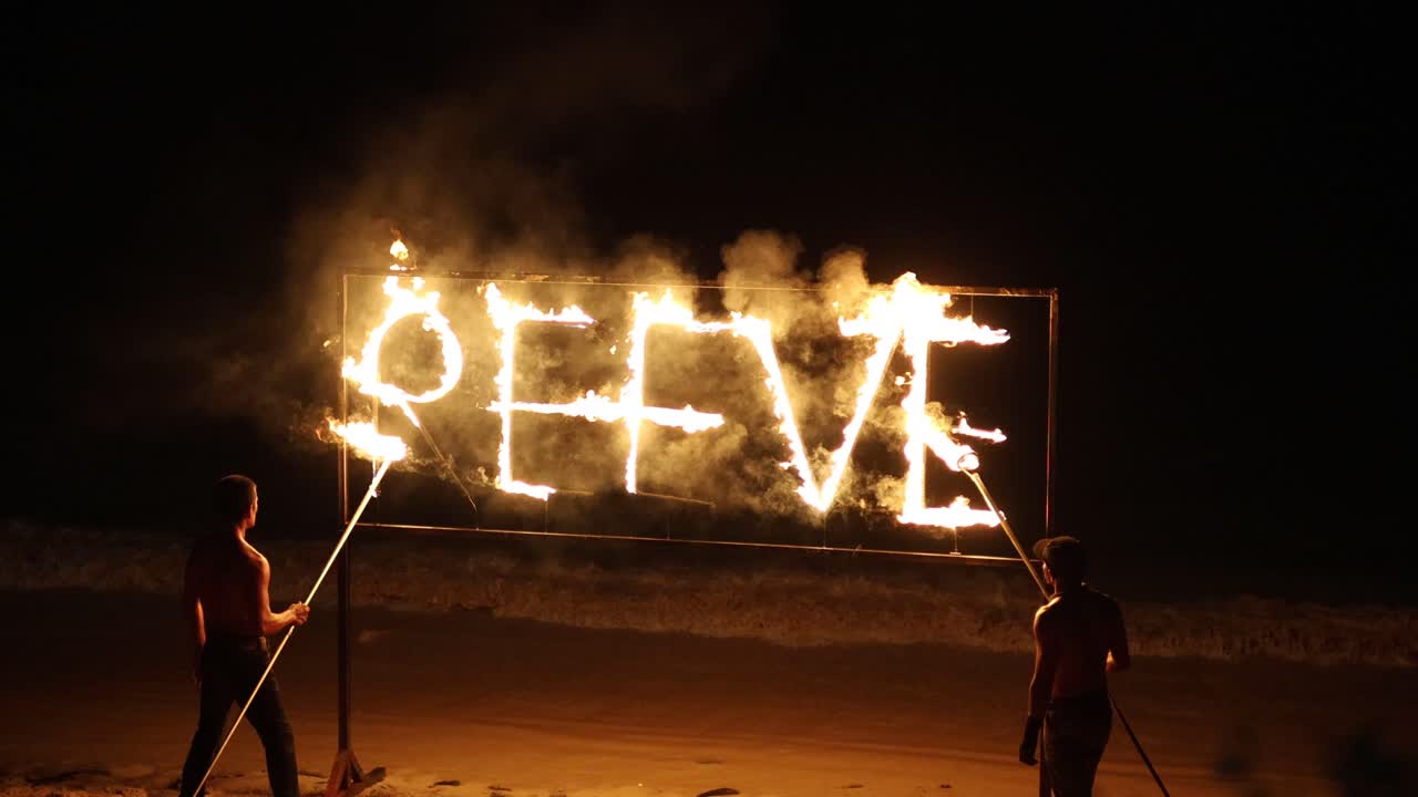 los artistas crean una exhibición de fuego en la playa