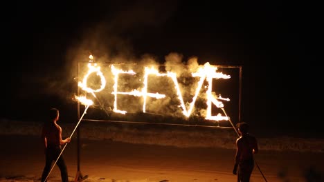 los artistas crean una exhibición de fuego en la playa