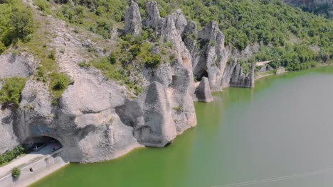 Imágenes-Aéreas-Panorámicas-De-Hermosos-Acantilados-Con-Túneles-De-Carretera-Rodeados-Por-Un-Lago-1