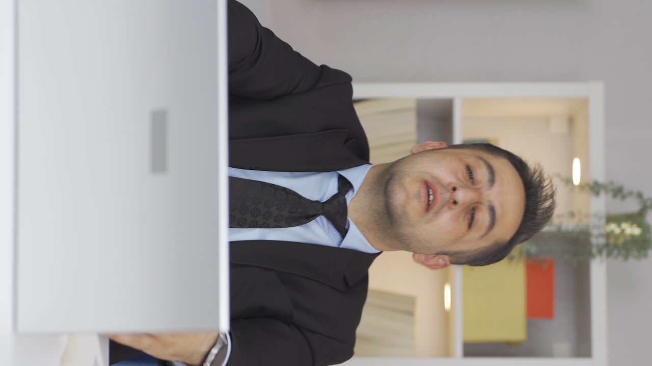 홈 오피스 근로자의 수직 비디오 남자는 그의 일을 완료하고 휴식을 취합니다.