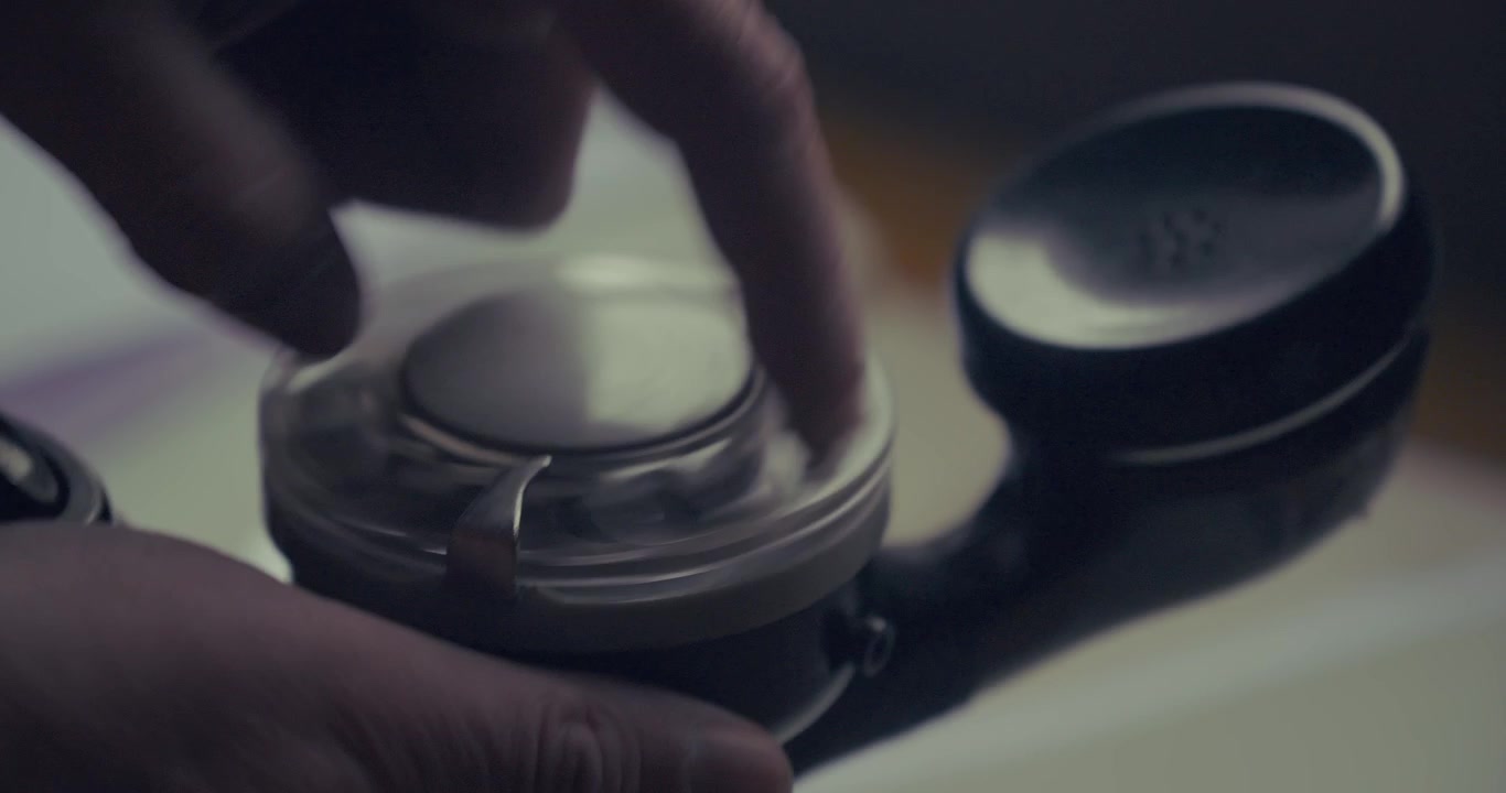 Macro close-up of a finger dialling a number on a vintage rotary engineer's buttset, illustrating analogue communication and telecommunications history.