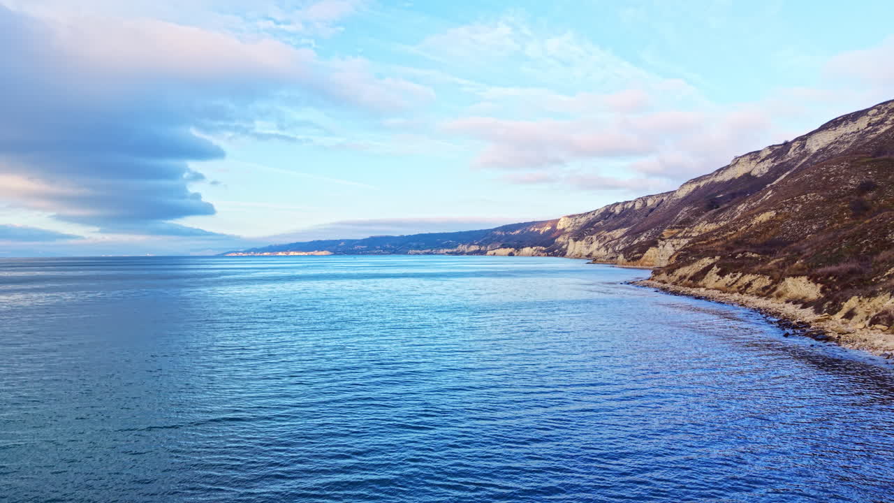 Vista panoramica di un paesaggio costiero con oceano e colline vicino alla riva durante il giorno lungo una spiaggia rocciosa