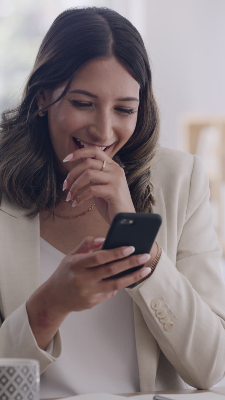 Giovane donna felice sorride e ride mentre usa lo smartphone