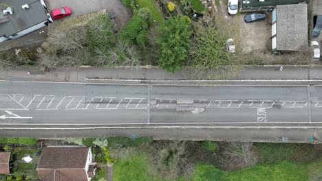 Cars-dangerous-swerving-around-large-pothole-UK-road-overhead-birds-eye-view