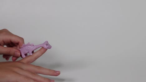 hand flinging a stretchy purple dinosaur toy