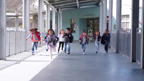 elementary school kids race to camera in school corridor