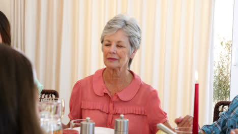 extended family saying grace before christmas dinner