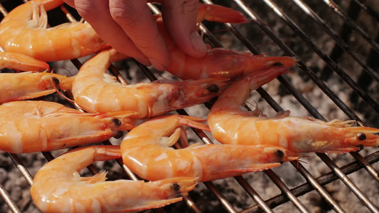 Chef cooking shrimps with oil and spices on grill close-up. Prawns on fire throwing them on pan. Restaurant Food concept. Sea food barbecue.