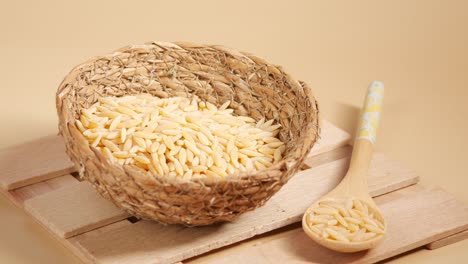 orzo pasta in a bowl with a wooden spoon