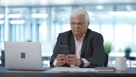 angry indian senior manager using mobile phone