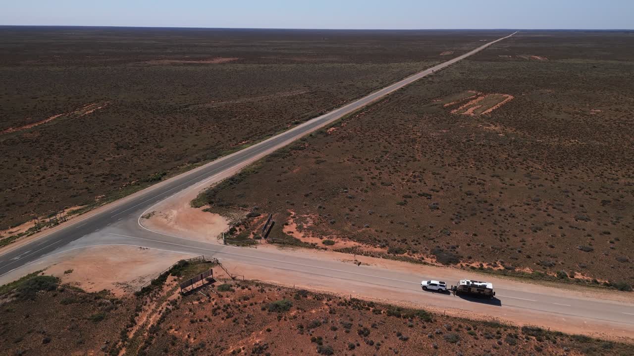 Cinematic pan around car towing caravan driving along the Nullabour in Australia