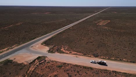 cinematic pan around car towing caravan driving along the nullabour in australia