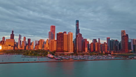 flying in front of a marina and the sunlit new eastside of chicago - aerial view