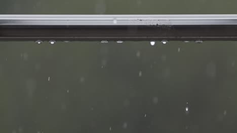 Close-up-video-of-rain-drops-falling-from-railing