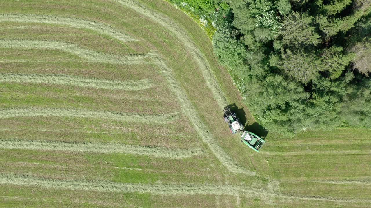 Bird's Eye View Of A Tractor Working On The Green Field - drone shot