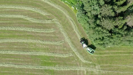 bird's eye view of a tractor working on the green field - drone shot