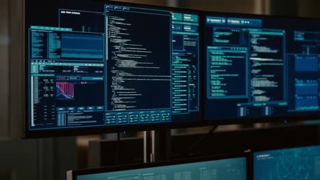 multiple monitors displaying cybersecurity data and code