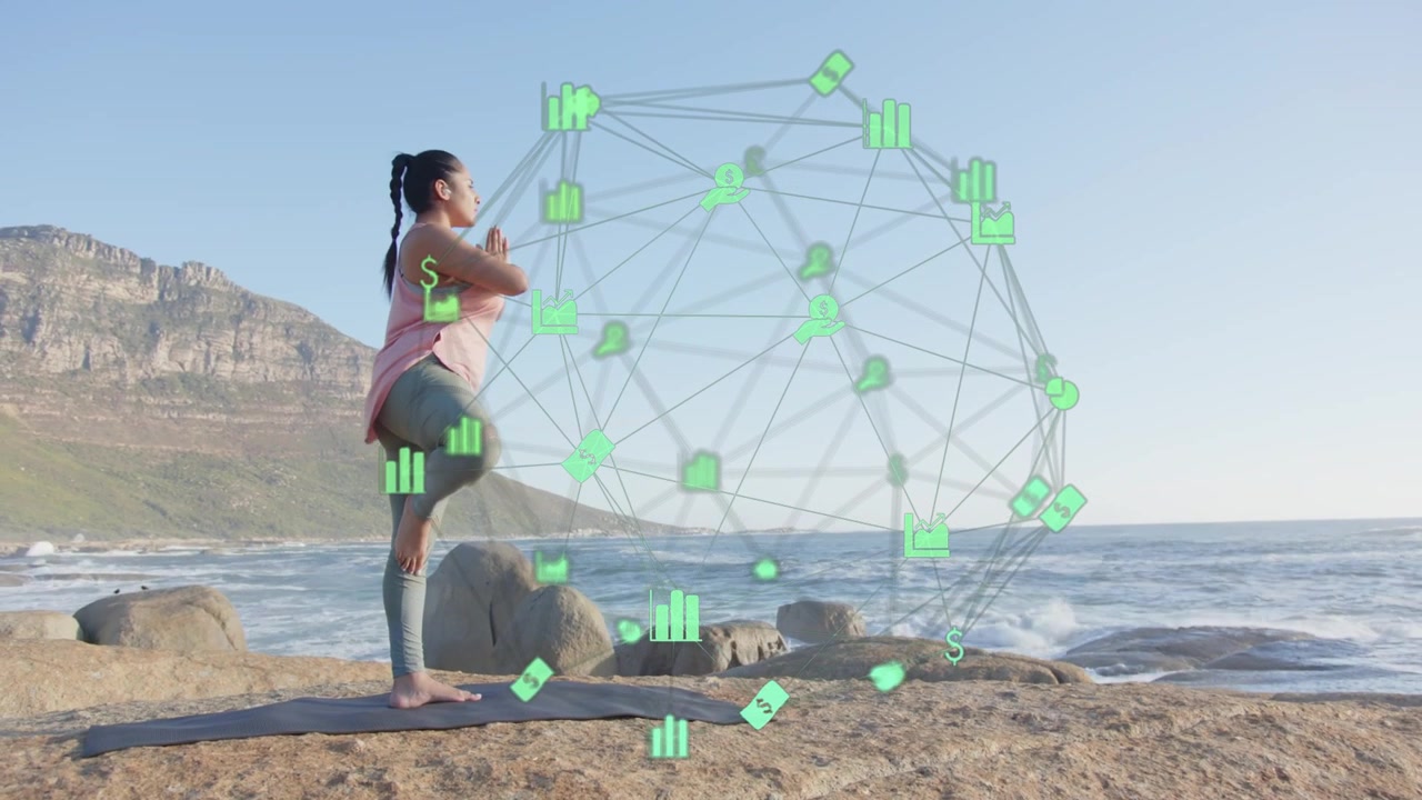 Donna che pratica una disciplina olistica su una roccia costiera, alzando le braccia e mantenendo l'equilibrio per il benessere, mentre un ologramma mostra grafici.