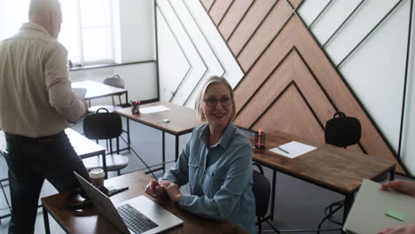 Senior-woman-sitting-at-desk-in-classroom