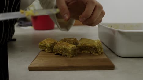 El-Chef-Coloca-Piezas-De-Baklava-En-Capas-Sobre-Un-Plato-De-Madera