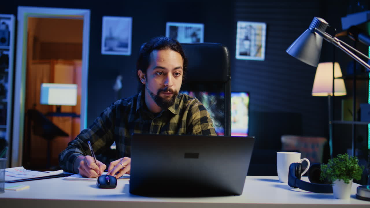 Freelancer noterer ideer ned på papir ved hjælp af pen, mens han telearbejder
