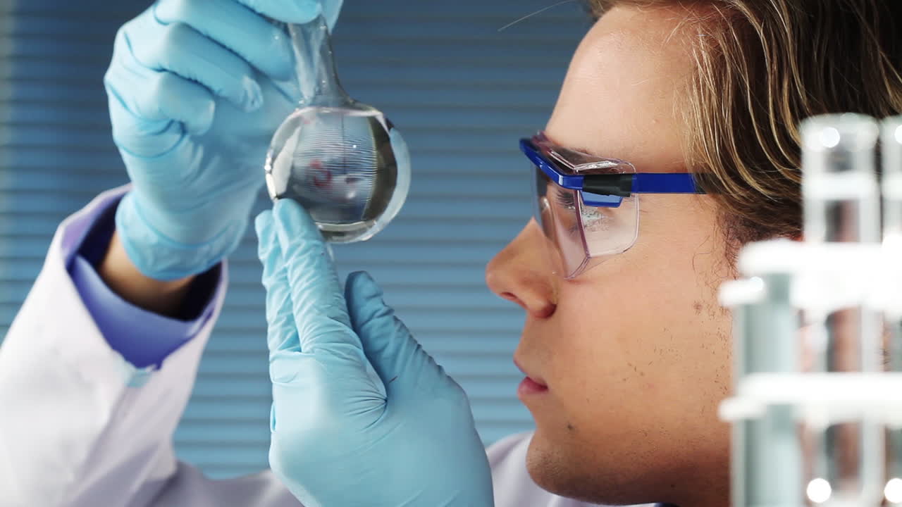Male scientist filling bottle for experiment