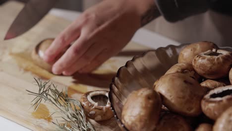 woman cutting mushroom on wooden chopping board