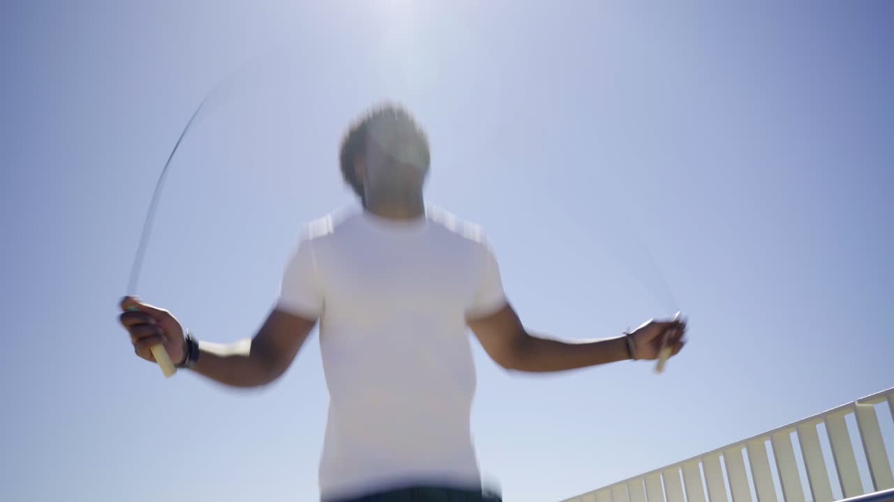 Bottom view of African American man skipping rope outdoor.